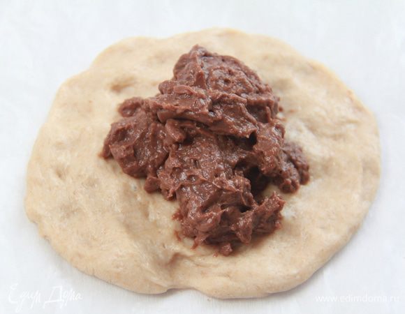 Из кусочка теста сформировать руками лепешку размером с ладонь, в центр положить 1-1,5 ст.л. крема.