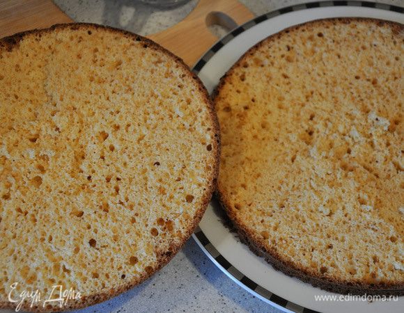 Остывший бисквитный корж разрезать на 2 части. Пропитать сиропом обе части. Для этого смешать воду, сахар и коньяк.