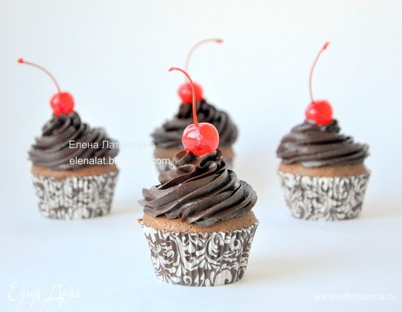 Для крема. Разогреть сливки и добавить шоколад. Растворить шоколад в горячих сливках до однородности. Остудить и взбить до состояния крема. С помощью кондитерского мешочка украсить капкейки, добавить вишенки.