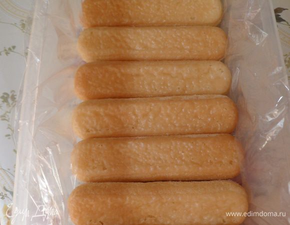 Делаем из пропитанного печенья первый слой, уложив  в форму, застеленную пищевой пленкой.