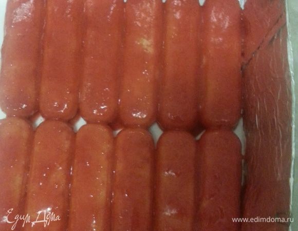 Первый слой савоярди хорошо окунаем в клубничное пюре и выкладываем на блюдо. Выкладываем половину крема.