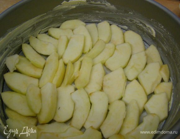 Очистить яблоки (2-3 шт., чтобы плотно покрыть дно формы); смазать стенки формы маслом, дно выстелить пергаментом, выложить яблоки.