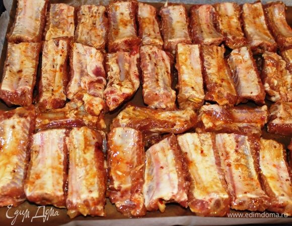 Выложить аккуратно ребрышки на противень (без маринада, чтобы не было лишней жидкости). Запекать при температуре 230 градусов 30 минут. Затем снизить температуру до 200 градусов.Смазать каждое ребрышко жидким медом (с помощью кулинарной кисточки) и запекать еще 15 минут. После этого перевернуть каждое ребрышко, смазать снова медом и запекать 15 минут. 