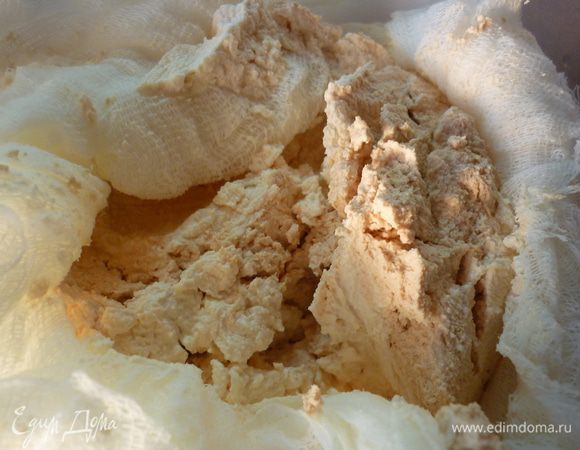 Я упомянула про грандиозную разборку в морозилке. Дело в том, что ряженку надо сначала заморозить. Я сделала это еще летом. А приготовление откладывала. Можно использовать и кефир, и варенец, и йогурт. Любой кисломолочный напиток. Возможно, сладкий или с добавками. В таком случае надо отрегулировать количество сахара. Замороженную ряженку теперь размораживаем. Я застелила марлей дуршлаг и поставила его в глубокую миску. Ряженку освободила от пакета и положила в марлю. Всю эту конструкция поместила в холодильник. Там происходил медленная разморозка в лечение 2 суток. Да, согласна, долго. Но ведь заморозка и размораживание происходит само по себе. Без напряга. Вот такая получилась нежная масса, напоминающая творожный сыр. А сыворотка - на блины.