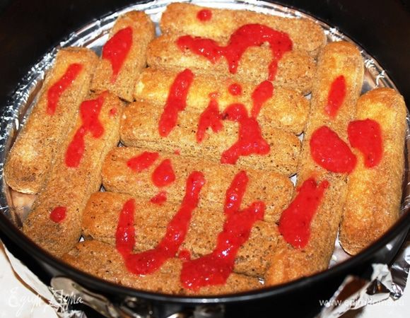 Печенье по одному смочить в кофе и выложить первым слоем в форму. Поверх печенья нанести половину оставшегося клубничного пюре. Не надо слишком обильно пропитывать печенье, достаточно просто обмакнуть.