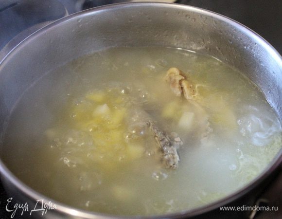 Наливаем в кастрюлю холодную воду, кладем куриное бедро и ставим на огонь. Как закипит снимаем пену, накрываем крышкой и пусть варится 20 минут. Затем добавляем картофель порезанный кубиком.