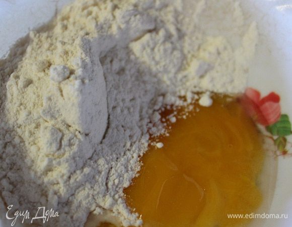 Делаем затируху. Для этого берем желток, к нему добавляем соль и воду. Хорошо размешиваем. Насыпаем муку с краю.
