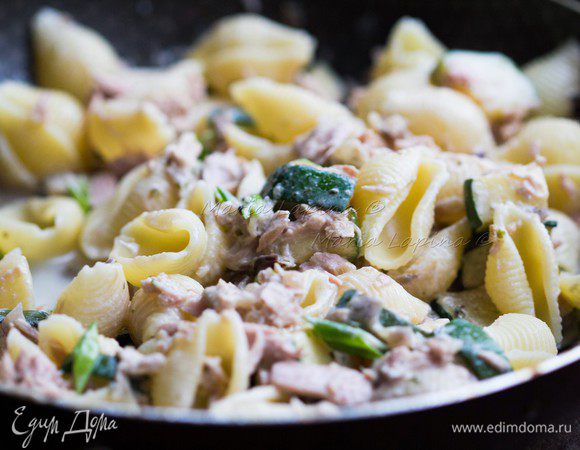 Добавить порубленный зеленый лук. Все перемешать, прогреть 1-2 минуты все вместе, выключить огонь и можно подавать блюдо. Разложить пасту по тарелкам, сверху присыпать натертым твердым сыром.