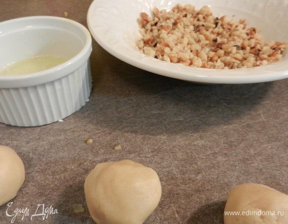 Сформировать шарики (2 ч. л. на каждый). Макать шарики поочередно сначала в взбитый вилкой белок, потом опускать в измельченные орехи.