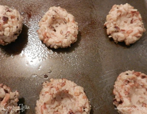 Выкладывать на смазанный маслом лист, придавливая пальцем посередине для получения углубления. Заготовки получатся размером около 5 см. Выпекать в заранее разогретой духовке в течение 5 минут при температуре 160°C. Вынуть из духовки и придавить пальцем посредине ямки снова. Отправить в духовку снова на 10–15 минут, пока заготовки для печенья не станут золотистого цвета. Вынуть, оставить на листе на 5 минут.