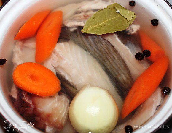 Первым делом нужно сварить насыщенный рыбный бульон.  У меня всегда остается много рыбных обрезков после разделки рыбы... И когда их набирается ОЧЕНЬ много, я варю насыщенный концентрированный бульон, разливаю его по небольшим контейнерам и замораживаю. По мере необходимости я его достаю, размораживаю и разбавляю до нужной концентрации. Очень удобно.  Кости, плавники и головы хорошо промыть, залить холодной водой, положить  целую луковицу и нарезанную крупными кусками морковь,  добавить соль, перец и лавровый лист. Довести до кипения, снять пену  и варить 25-30 минут. Затем процедить. Бульон готов.