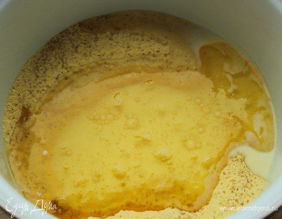 Влить масло и молоко. Поставить кастрюлю на слабый огонь и нагреть, постоянно помешивая.