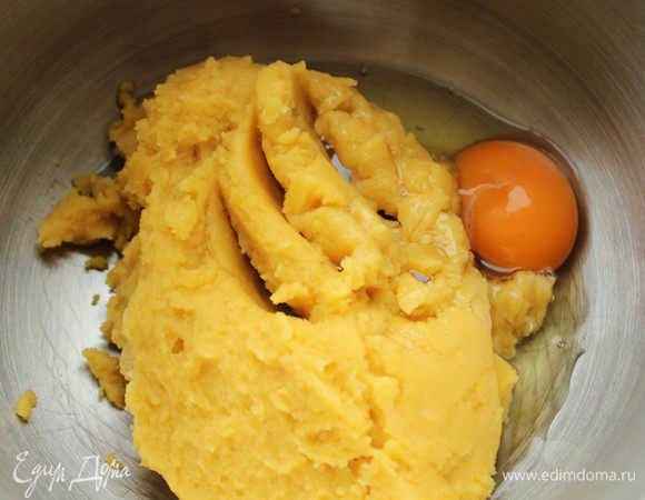 Тесто слегка охладить и переложить в чашу комбайна. Если вы будете перемешивать тесто вручную, то можно оставить в той же посуде. По одному вбить яйца, всыпать кокосовую стружку, добавить ванильную эссенцию и разрыхлитель. Все хорошо перемешать.