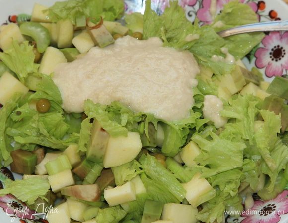 К нарезанным ингредиентам рвем листья салата и добавляем 2 столовые ложки заправки.