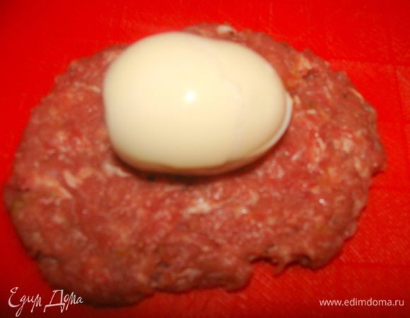 Фарш разделить на равные комочки, брать по одному, делать лепешечку, класть на нее яйцо и формировать ежика.