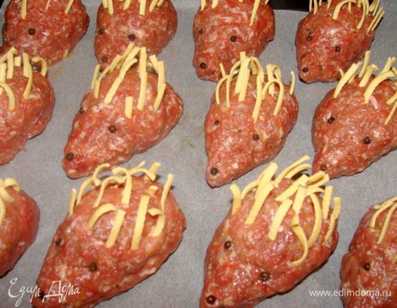 Каждого ежика обмакнуть в яцо, взбитое вилкой. Носик ёжикам лучше приподнять к верху, чтобы в последствии они не получились угрюмые))) Выложить всех на противень, застланный пекарской бумагой. Из черное перца сделать глазки и носик, можно заменить кусочками маслин или горбушки черного хлеба. Иголки из лапши. 