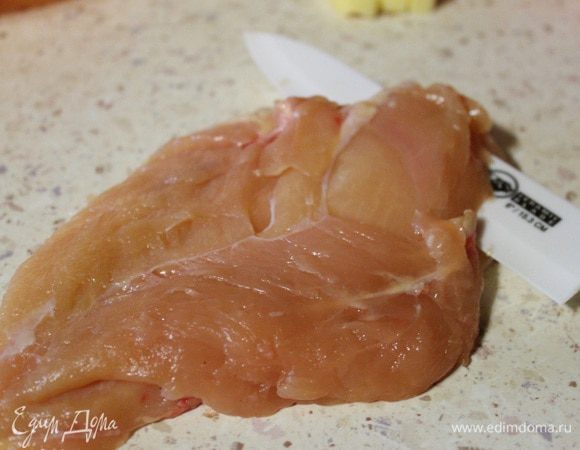 Куриную грудку разделить на два филе, обрезав по кости. Затем каждое филе разрезать вдоль острым ножом. В Итоге получается 4 филе.