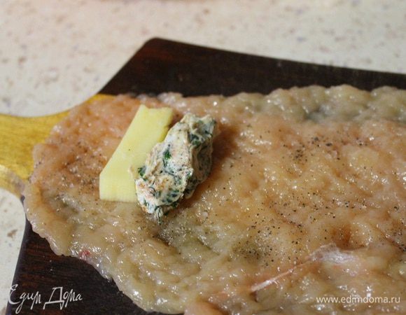 Теперь кладем на отбитую грудку небольшой кусочек сыра и небольшой комочек масла..