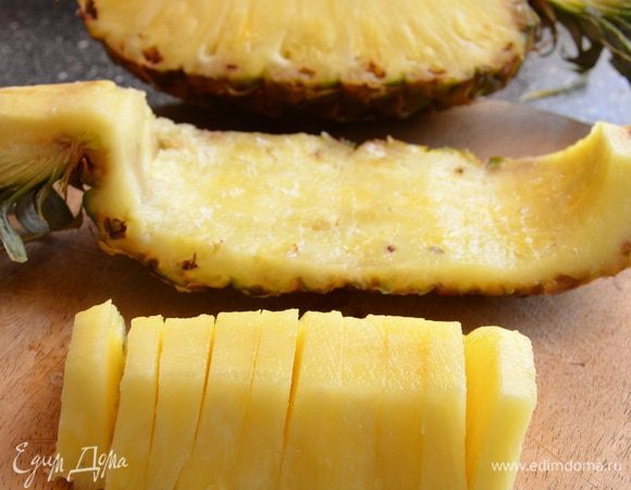 Ананас делим на 4 части. Середину твердую срезаем. Мякоть аккуратно вырезаем ножом и режем на ломтики.