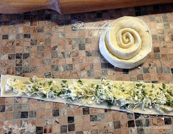 На полоски сверху выкладываем начинку, тщательно защипываем края и сворачиваем по спирали.