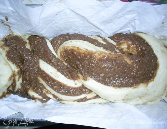 Поворачиваем части рулета срезом вверх и переплетаем жгутом. Выкладываем жгут в подготовленную прямоугольную форму, выстеленную влажной бумагой для выпечки. Оставляем на час в теплом месте для расстойки, затянув форму с рулетом пищевой пленкой.