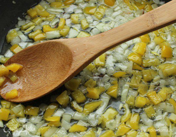 На этом же масле обжарить нарезанные мелким кубиком болгарский перец и лук до золотистого цвета, затем добавить рубленный помидор.