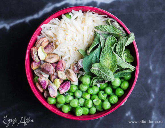 Фисташки очистим от скорлупы, нарвем листики мяты, горошку дадим немного нагреться при комнатной температуре или поставив на полминутки в свч. Сыр натрем на терке, зубчик чеснока порубим крупно. Сложим все в чашу блендера. Добавим оливкового масла и немного воды.