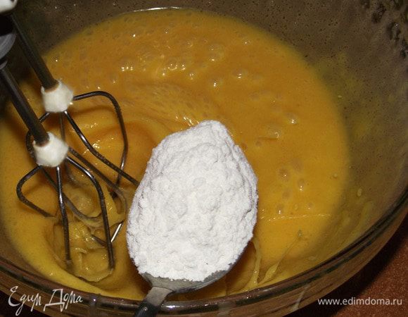 К массе постепенно добавить просеянную с разрыхлителем муку.