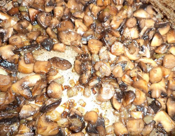 Лук очистить, нарезать кубиками. Шампиньоны порезать. В сковороде разогреть растительное масло, обжарить грибы с луком, посолив и поперчив.