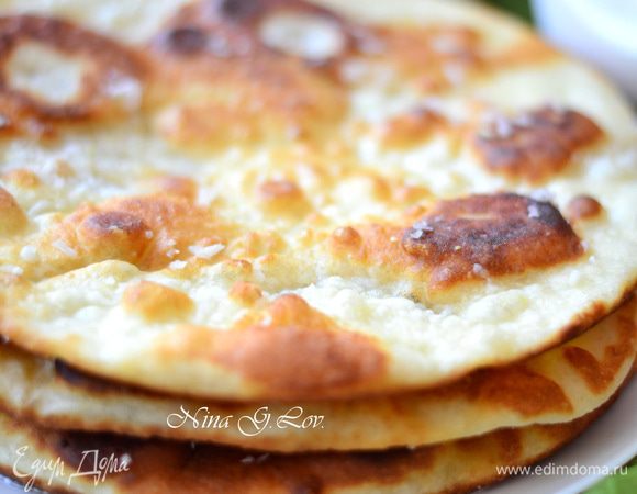 Выложить лепешку на бумажное полотенце, смазать ее  чесночком,