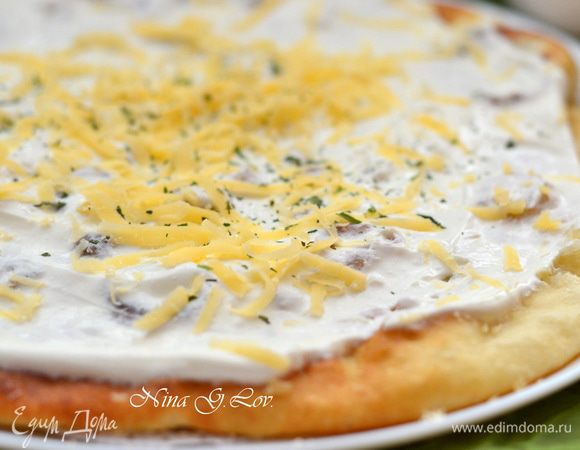 Щедро обмазать сметаной и посыпать тертым сыром.