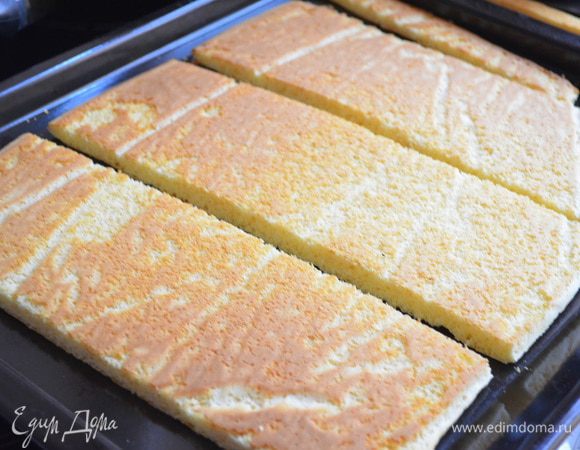 Еще теплый бисквит отделяем от бумаги и разрезаем на ровные 3 части, обрезав неровные края.