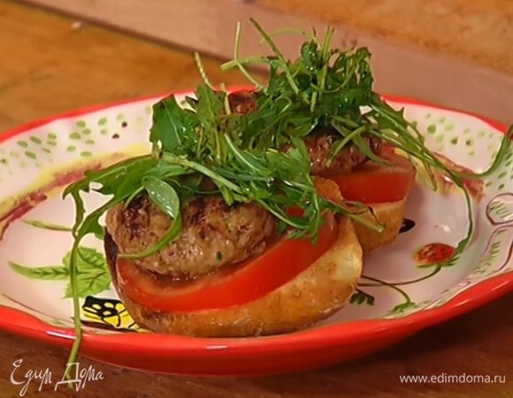 На обжаренный хлеб выложить кружки помидора и котлетки, а сверху листья руколы.