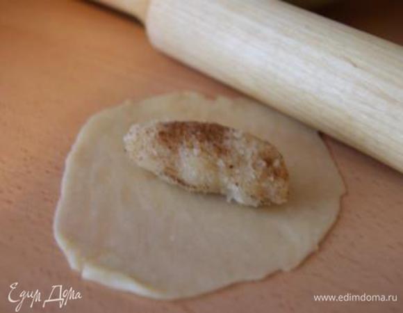 Тесто разделить на кусочки. Их количество должно быть равно количеству миндальных колбасок. Тесто очень тонко раскатать. Выложить колбаску и сформировать в форме полумесяца.