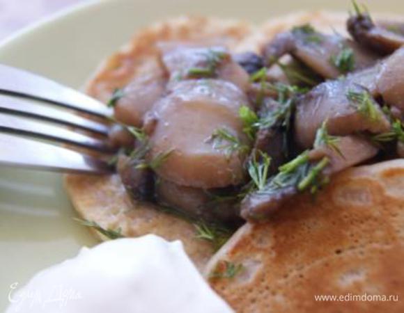 Готовые блинчики выложить по тарелкам, сверху выложить грибы, подавать со сметаной. Приятного завтрака!