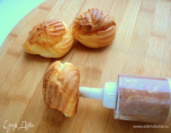 Профитроли разделить на 3 части (у меня получилось по 10 шт) и наполнить с помощью кулинарного шприца разными кремами.