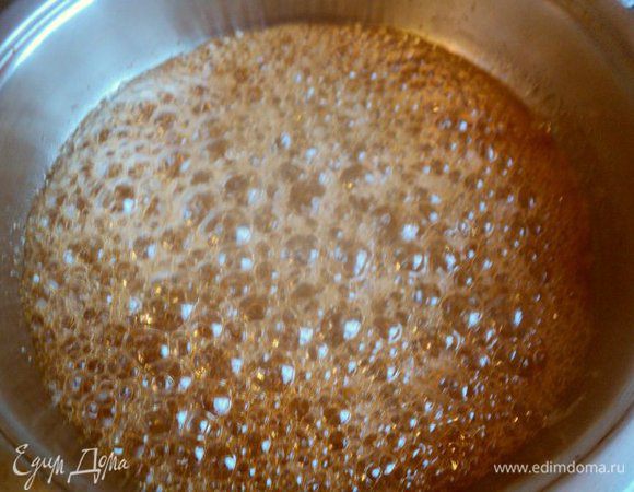 Сварить карамель для украшения торта. На сковородку высыпать сахар, добавить воду и лимонный сок и на небольшом огне довести сироп до золотистого цвета и карамелизации. Карамель не мешать, а только слегка потряхивать емкость.