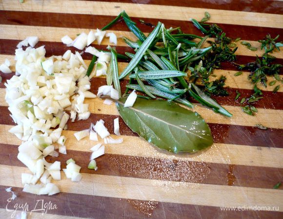 За это время приготовим начинку для мяса. Чеснок очистим и мелко порежем. Иголочки розмарина и листики тимьяна отделим от веточек.