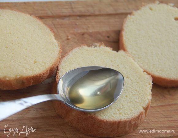 Готовый бисквит полностью остудить. Разрезать на три коржа (я разрезала на следующий день). Каждый корж пропитать белым десертным вином (примерно 2-3 ложки на каждый корж).