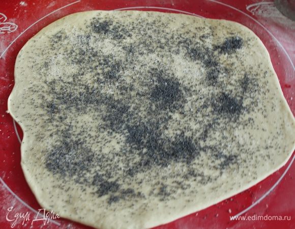 Разделить тесто на две части, одну раскатать, смазать растительным масло, посыпать сахаром, маком, немного прикатать скалкой.