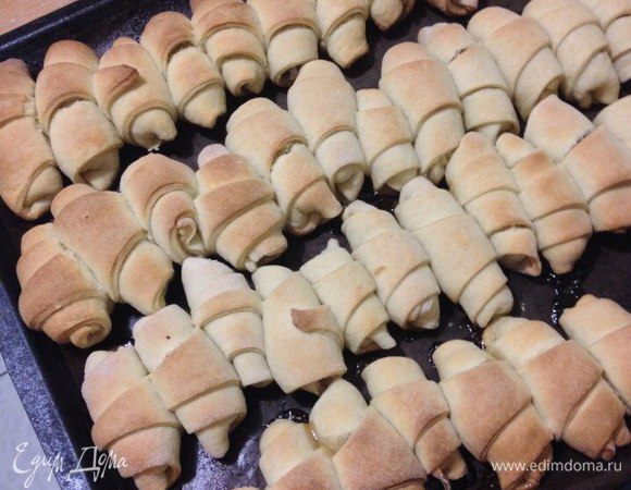 Разделите тесто на 8 частей. Включите духовку на 220°C. Возьмите одну часть, раскатайте круг и разрежьте его на 8 секторов. У вас получатся треугольники.