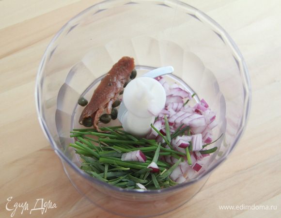 Измельчить в блендере зелень, лук, каперсы и анчоусы.