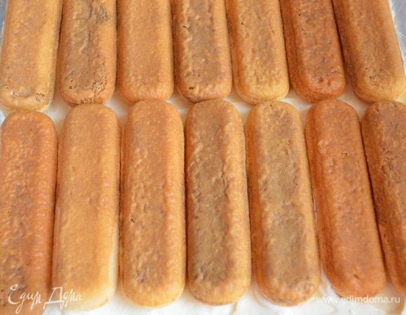 Первый слой наполняем творожно-сливочным кремом, затем сверху укладываем пропитанное печенье.