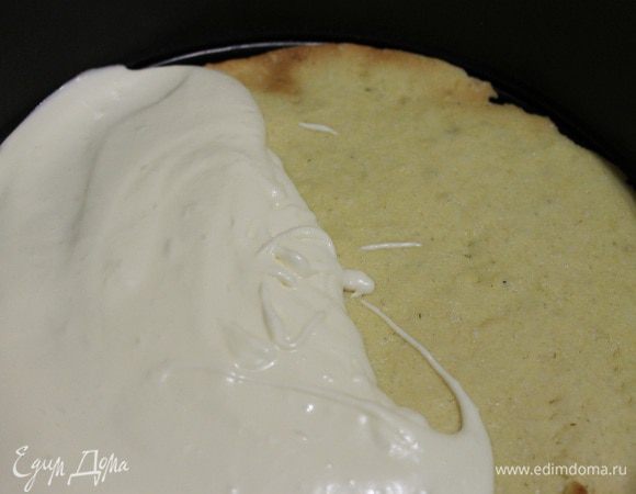 Снимаем с разъемной формы кольцо, кладем его на ровное блюдо и с внешней стороны приклеиваем его скотчем к блюду. Выкладываем корж в кольцо, сверху чуть меньше половины суфле и накрываем вторым коржом.