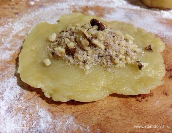 Каждый шарик расплющить ладонями в лепёшку (в середине чуть тоньше) и положить в середину начинку.
