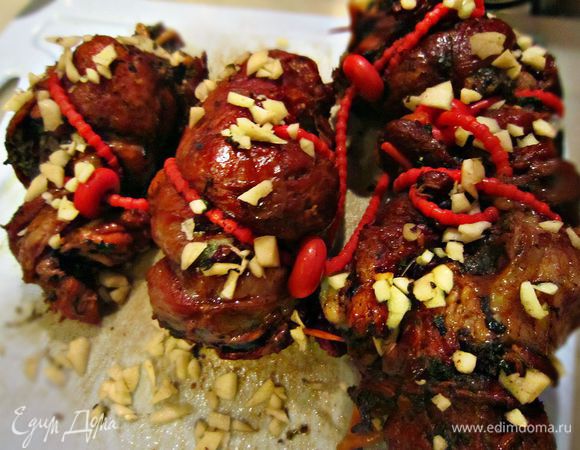 Готовые рулеты вынуть из отвара. После варки в луковой шелухе они приобретают прекрасный яркий цвет. 
2 зубчика чеснока порубить, смешать с молотым перцем и обвалять в полученной смеси рулеты. Поместить рулеты между двумя досками, сверху положить гнёт и выставить на холод (не менее 3 ч, лучше - на ночь).