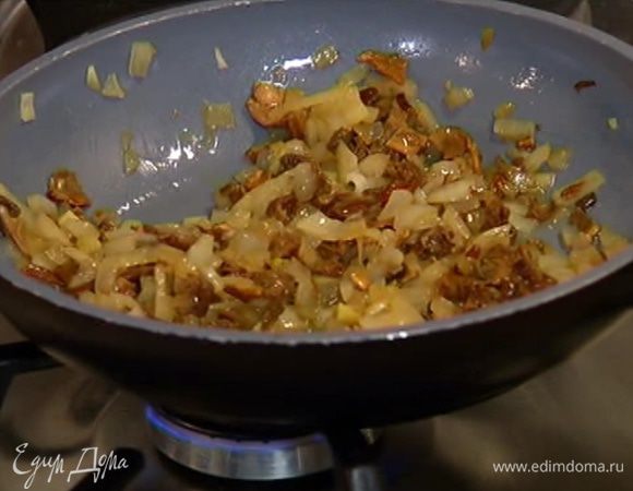 Разогреть в сковороде оливковое масло, обжарить лук и чеснок, затем добавить измельченные грибы и прогревать все на медленном огне 5–7 минут, чтобы лук стал прозрачным.