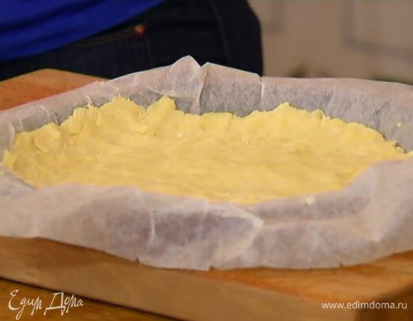 Оставшимся сливочным маслом смазать пекарскую бумагу, выстелить неглубокую форму для выпечки, выложить тесто, быстро распределить его по дну и бортикам формы и отправить в морозильник.