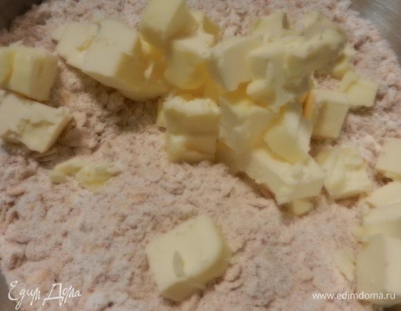 В этой же большой емкости смешать 1 ст.муки, 3/4 ст. овсяных хлопьев, 1/2 ст.л. разрыхлителя, 1/3 ст. коричневого сахара, 1/4 ч.л. соли и 1 ч.л. молотой корицы, все вместе перемешать. Очень холодное масло (1/2 стакана =125 мл) режем на маленькие кубики и вмешиваем, втираем масло со всем остальным, используя ладошки и большие пальчики.