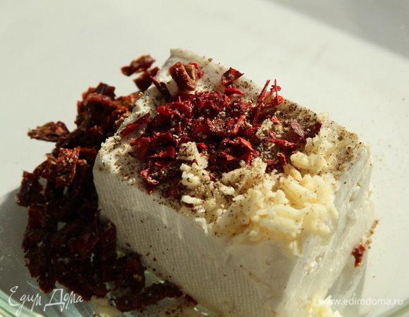 К брынзе добавляем лепестки паприки, черный молотый перец, нарубленный мелко чеснок, мелко нарезанные вяленый помидоры.